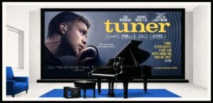 A grand piano stands in a living room with a large cinema screen behind it. A small open safe and headphones are placed near the piano.